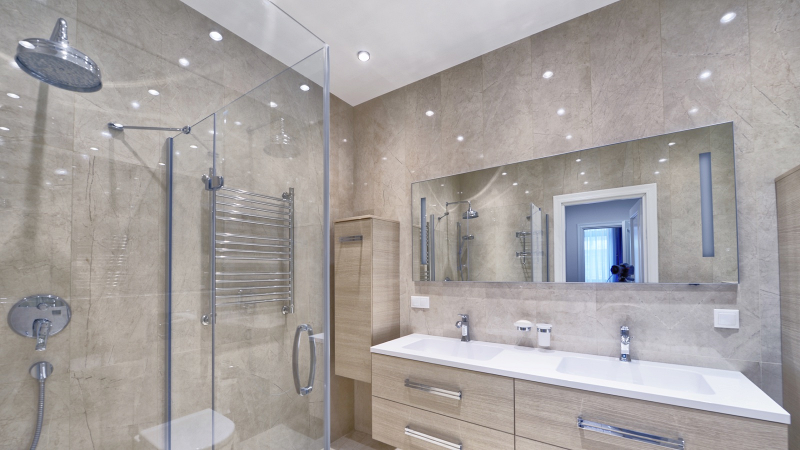 Modern ensuite with marble-look tiling, a glass corner shower, chrome heated towel rail and a timber double vanity